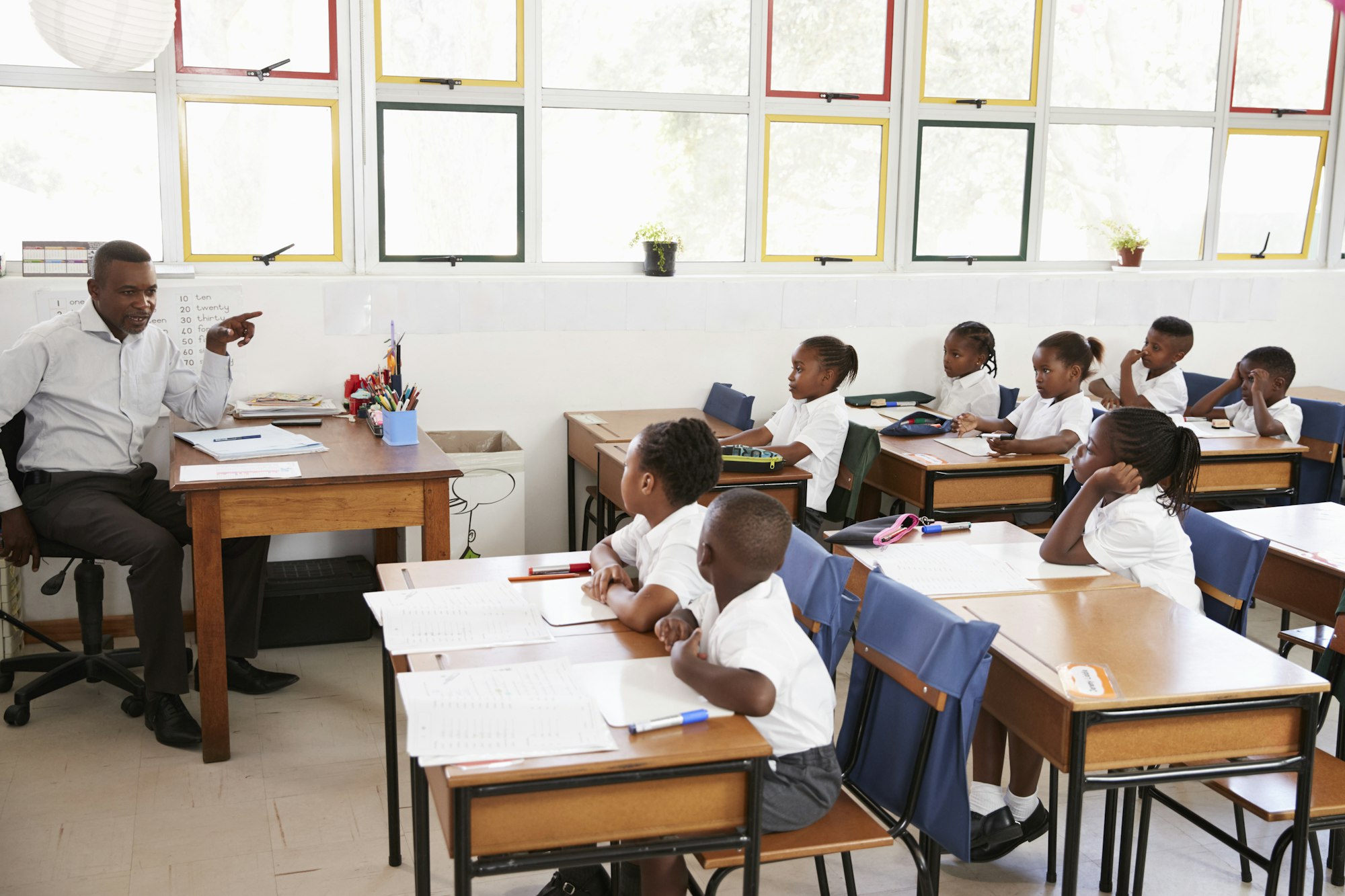 Teacher teaching kids from his desk at an elementary school